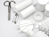 A detailed flat lay of essential first aid supplies including bandages, scissors, and pills.