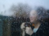 A blurry image of a woman looking out a window