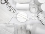 A flat lay of essential first aid supplies including bandages, gloves, and medications.