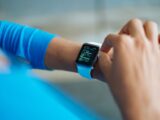 Person interacting with a smartwatch, showing a fitness application on the screen.